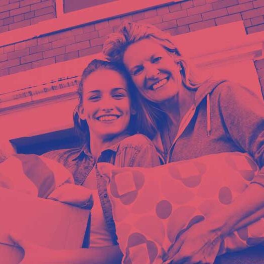 young adult with an older adult holding a pillow, teddy bear and moving boxes young adult with an older adult holding a pillow, teddy bear and moving boxes
